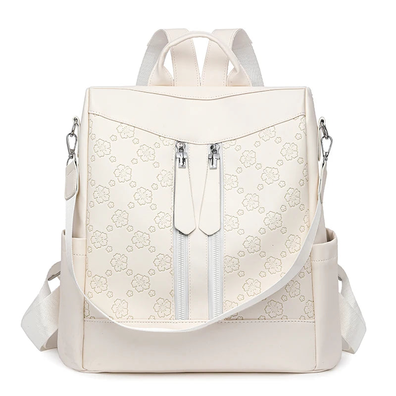 A beige leather backpack with light floral embroidery and adjustable straps.
