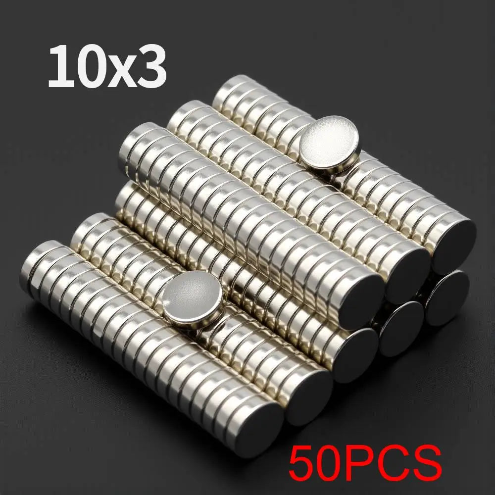 A collection of 50 small silver disc magnets arranged in a 10 by 3 grid.