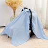 Light blue breathable cotton muslin car seat and stroller cover draped on a fluffy rug.