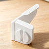 A white masonry line corner clip with an anti-slip lock mechanism shown on a wooden surface.