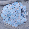 A pile of light blue heart-shaped embroidered iron-on patches for DIY clothing decoration