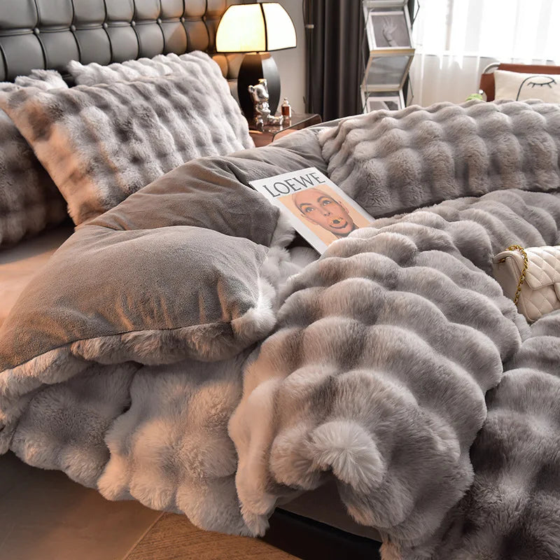 A fluffy gray faux fur duvet cover and pillows with a small sign on the bedding.