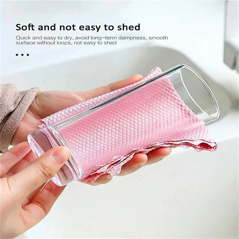A hand holds a pink lint-free microfiber cleaning cloth, demonstrating its soft texture and ease of use.
