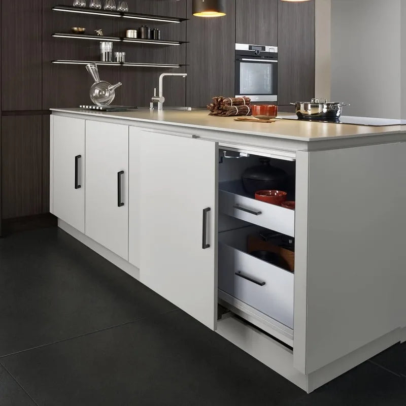 A modern kitchen cabinet with matte black stainless steel pulls and a light countertop and dark gray cabinetry.