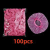 A package of 100 pink disposable shower caps for hair protection and salon use.