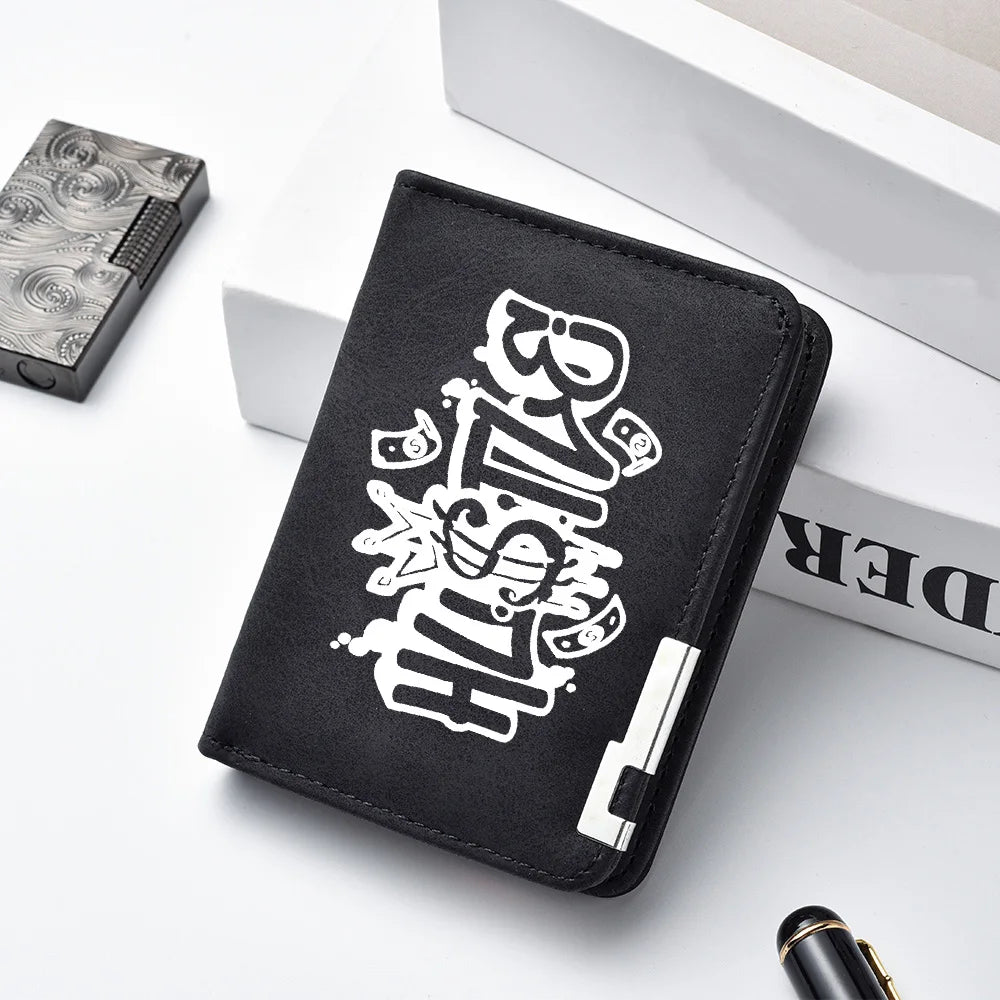 A black men's compact double-fold wallet with white text and design is shown next to a silver box.