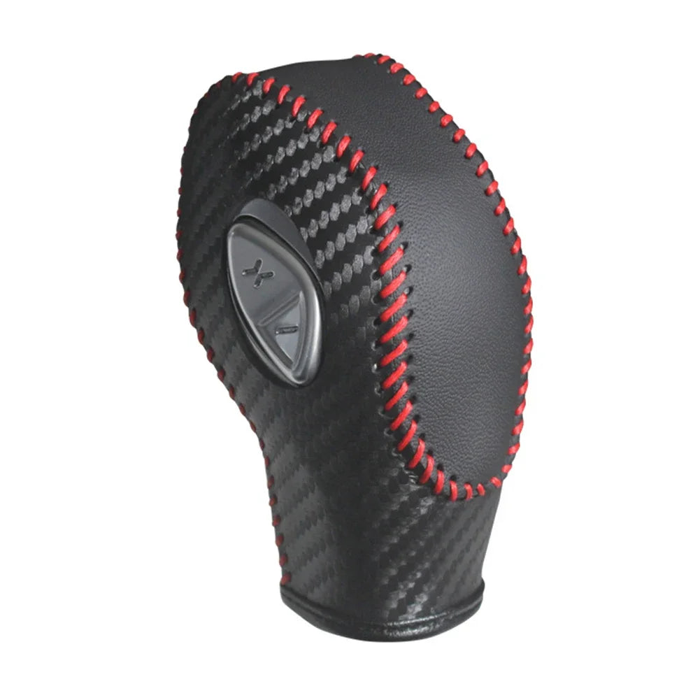 Black carbon fiber gear shift knob cover with red stitching and a silver accent.
