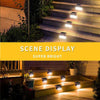 A series of solar deck lights illuminate outdoor steps and landscaping at night.