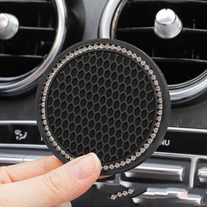A black crystal rhinestone non-slip cup mat is shown being held over a car stereo or accessory panel.
