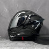 A black modular flip-up motorcycle helmet is displayed against a gray textured background.