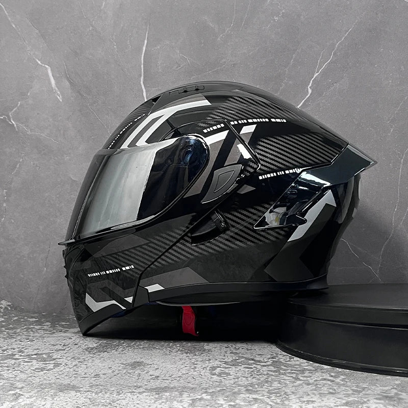 A black modular flip-up motorcycle helmet is displayed against a gray textured background.