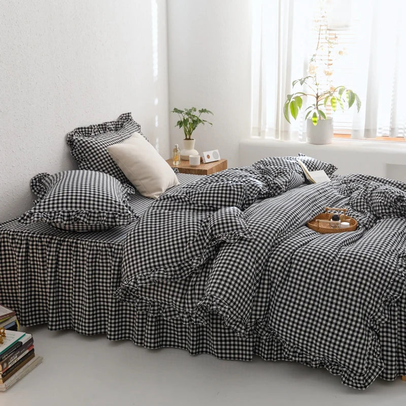 A black and white plaid duvet cover set with matching pillowcases displayed on a bed in a bright room.