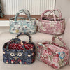 Three quilted fabric storage baskets in floral patterns, including blue-green, pink, and dark blue.