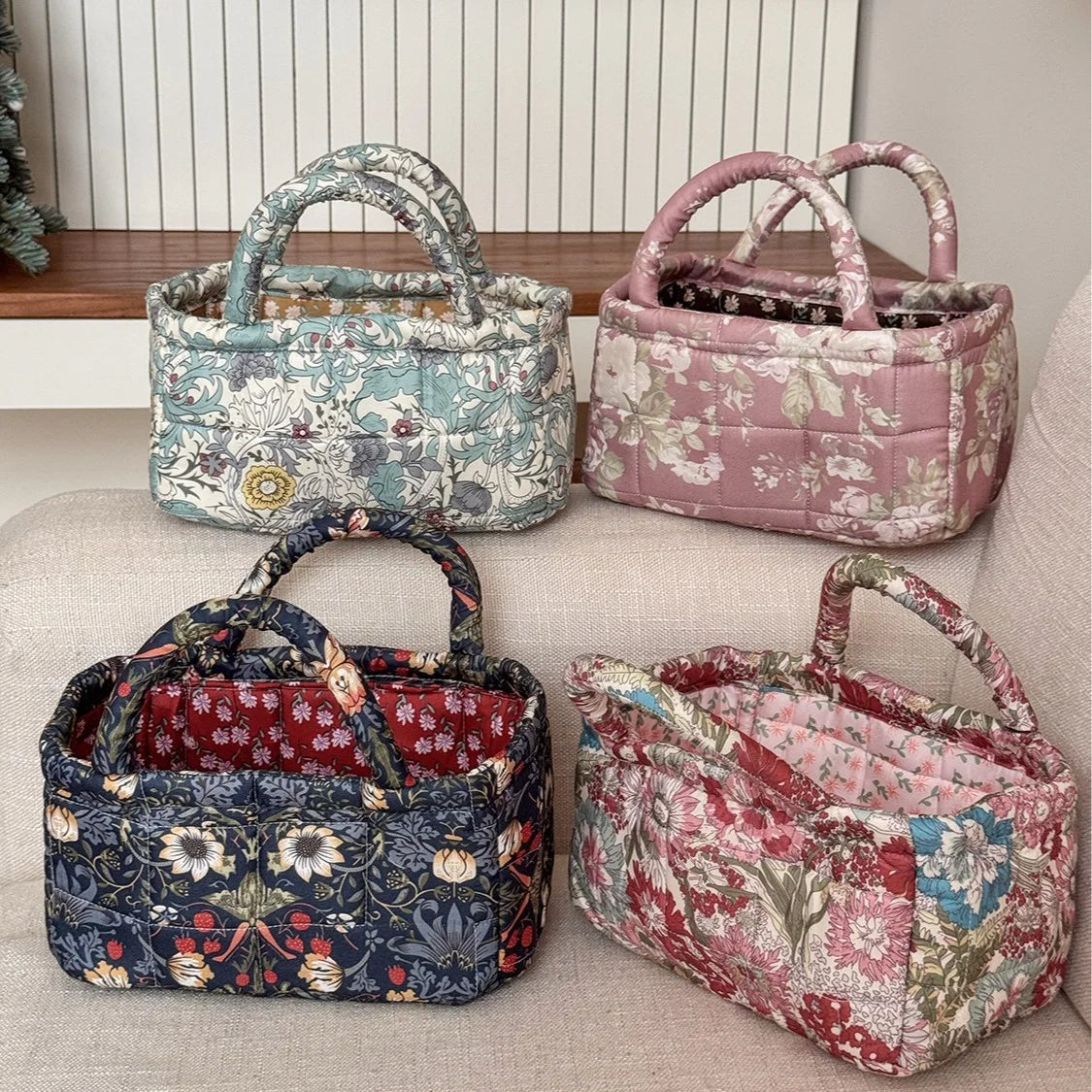 Three quilted fabric storage baskets in floral patterns, including blue-green, pink, and dark blue.
