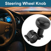 Close-up view of a black steering wheel knob used as a one-hand driving aid inside a car interior.