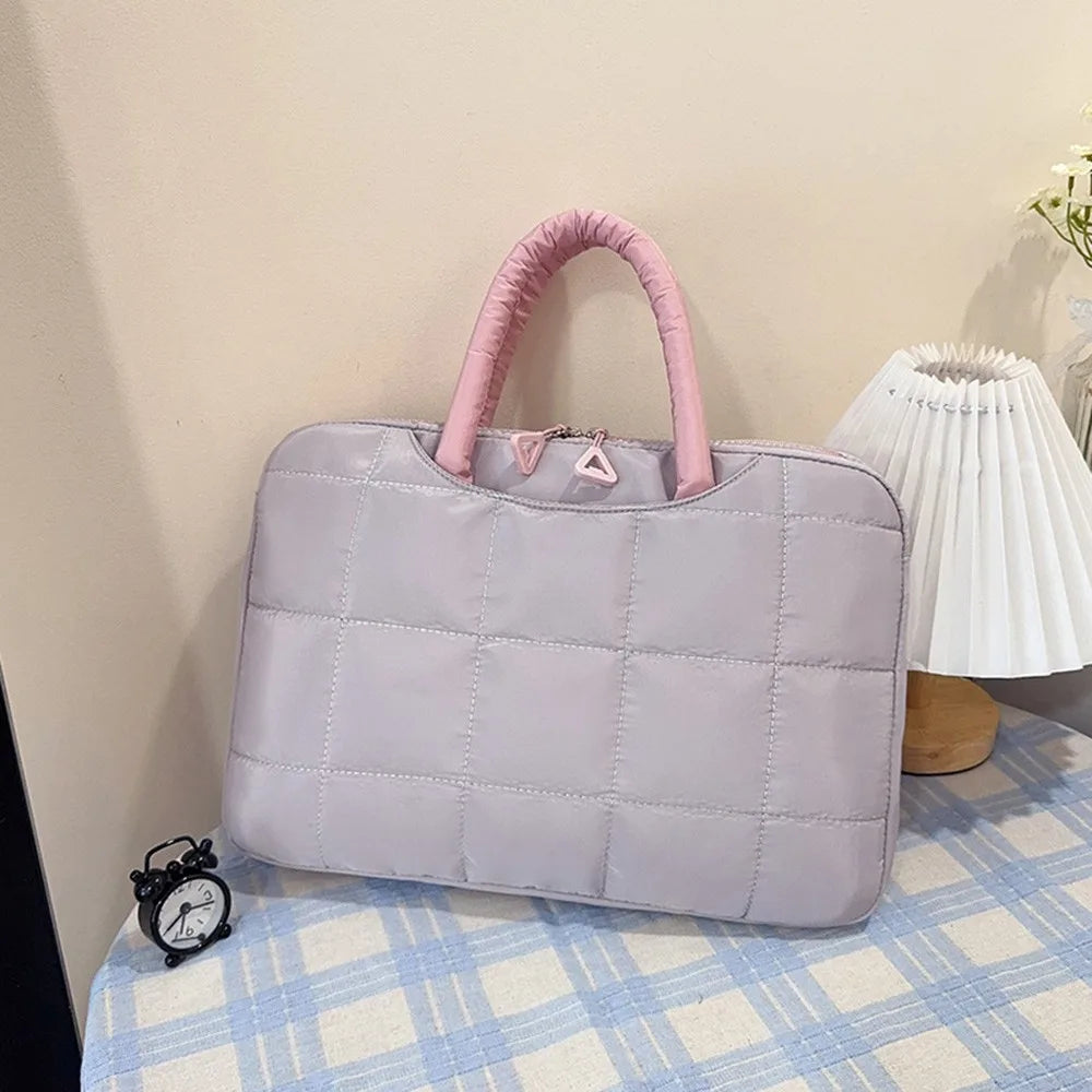 Sac à dos de laptop en nylon rembourré violet clair avec poignée rose sur une surface à carreaux bleus.