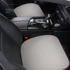 Interior view of a car seat showing a beige breathable cushion placed on the seat.