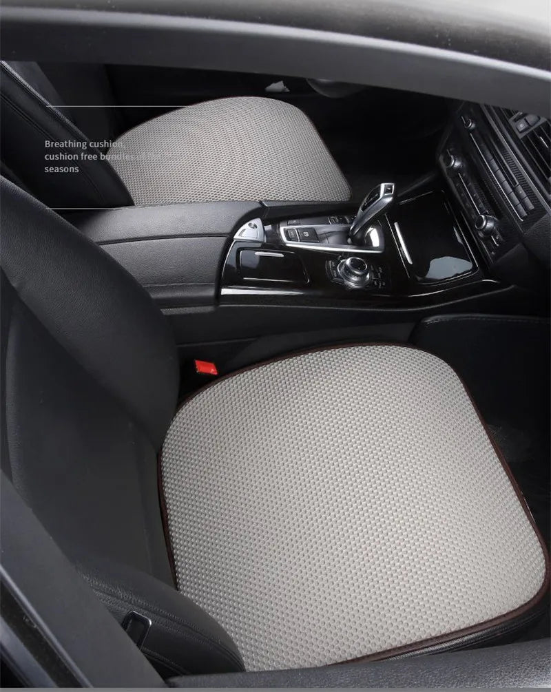 Interior view of a car seat showing a beige breathable cushion placed on the seat.