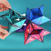 A hand holds a colorful magnetic fidget cube puzzle that transforms into a 3D geometric shape.