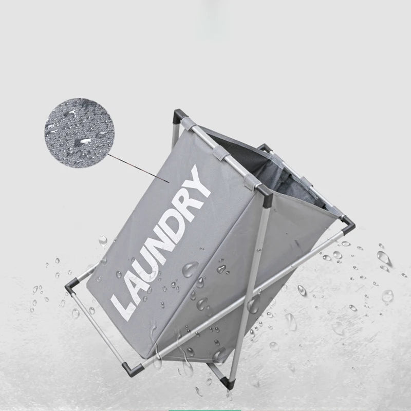 A gray foldable laundry basket is shown with water droplets splashing around it.