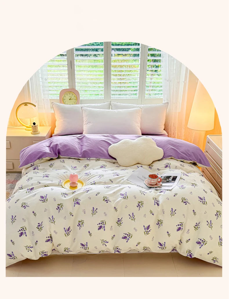 Lavendelfarziges Blumen-Duvetcover auf einem Bett mit weißen Kissen und natürlichem Licht.