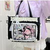A transparent shoulder bag with black trim and white lace trim is carried by a person wearing a light purple blouse.