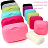 A collection of colorful, snap-proof travel soap dishes and a white soap bar shown in various shades.