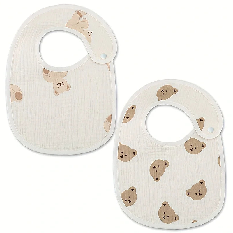 A pair of light beige baby cotton gauze bibs with a subtle pattern featuring small bear faces.