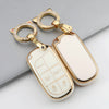 A gold-toned key fob with a clear plastic cover and a matching ring is shown against a gray background.