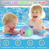 A baby is playing in water with a light-up whale bath toy that sprays water and provides sensory training.