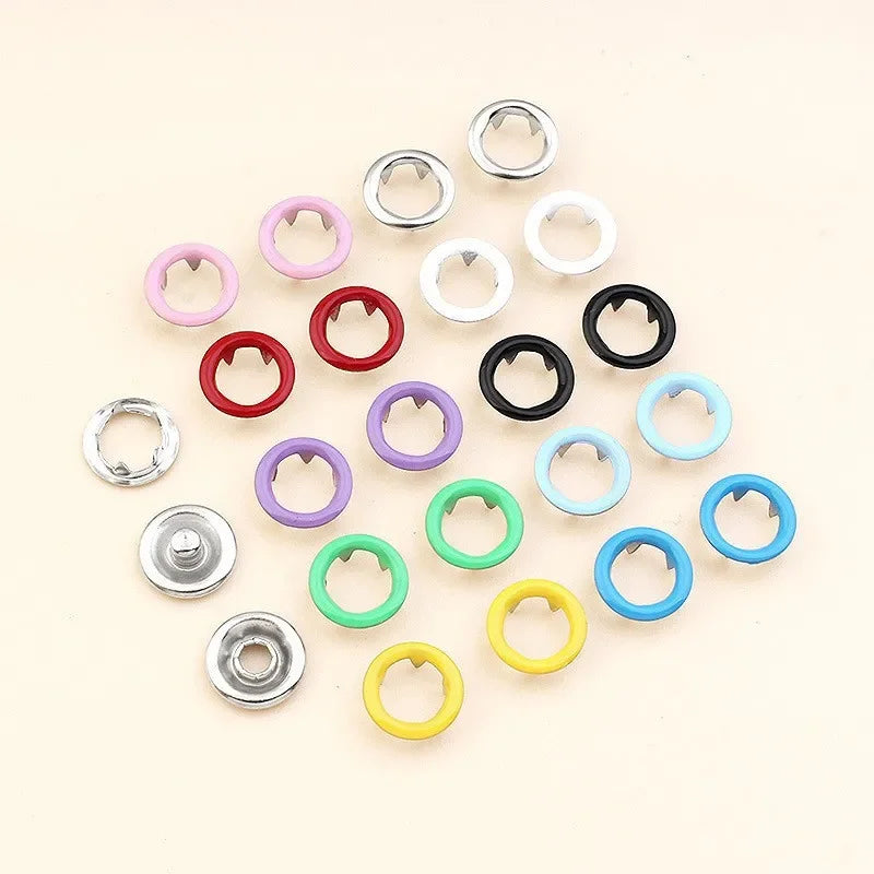 Colección de pinzas de hebilla metálicas de varios colores dispuestas en patrón radial.