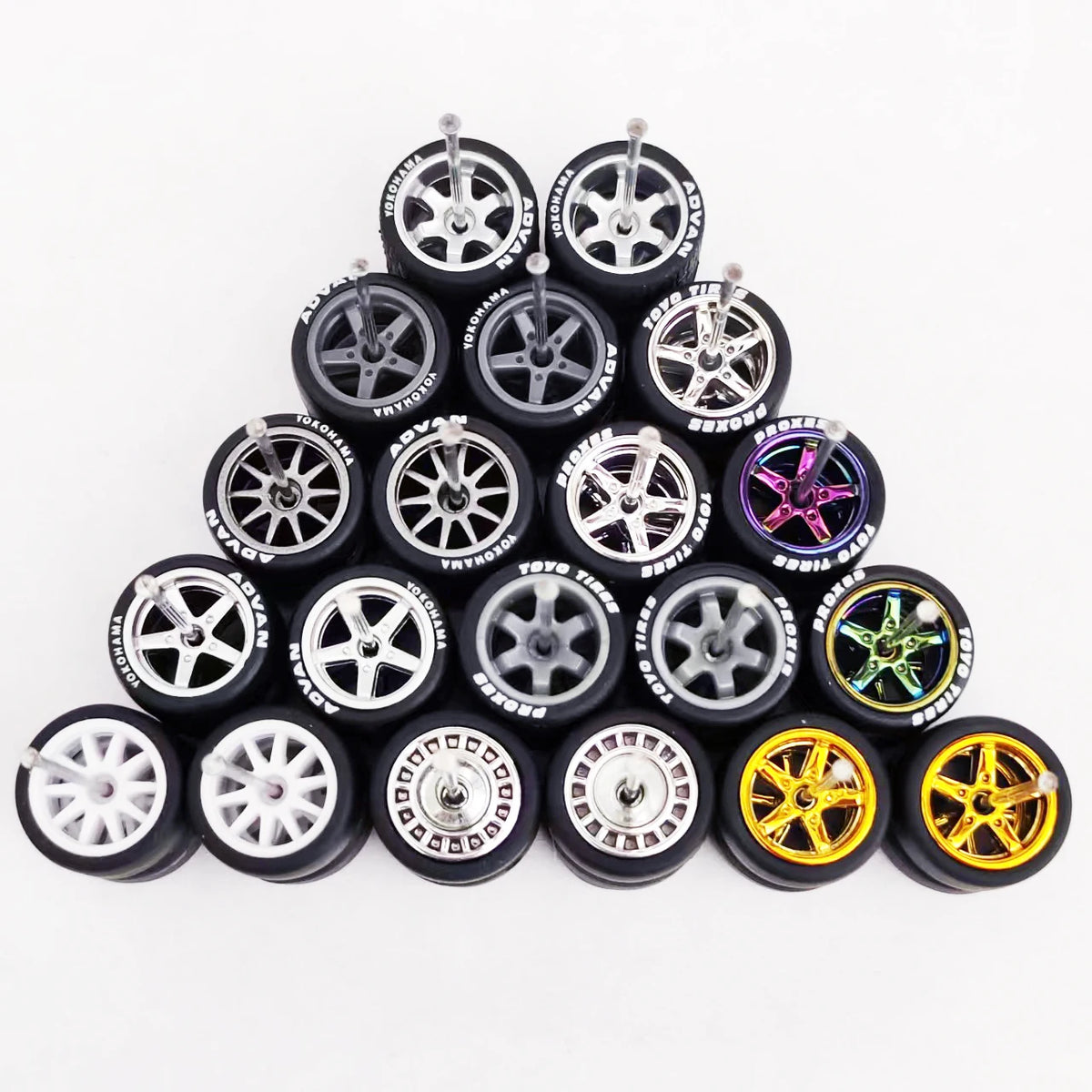 A collection of ten 1:64 scale alloy car wheels and tires arranged in a pyramid formation.