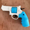 A white and blue mini mechanical revolver water gun is shown resting on a wooden surface.