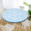 A round table covered with a light blue floral patterned tablecloth in a bright room.