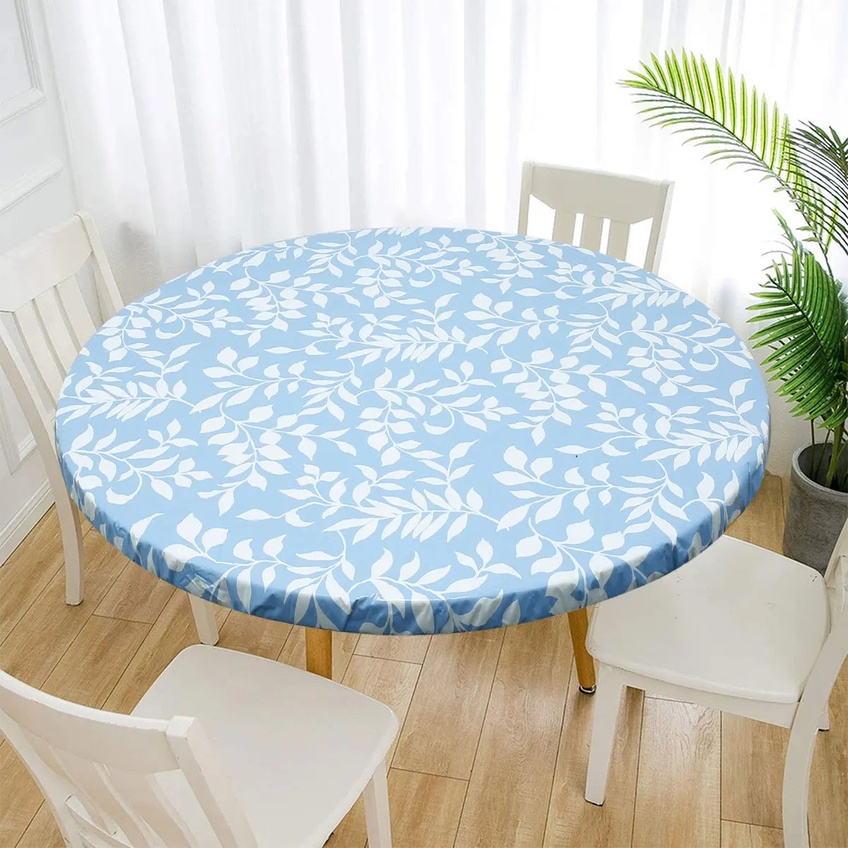 A round table covered with a light blue floral patterned tablecloth in a bright room.