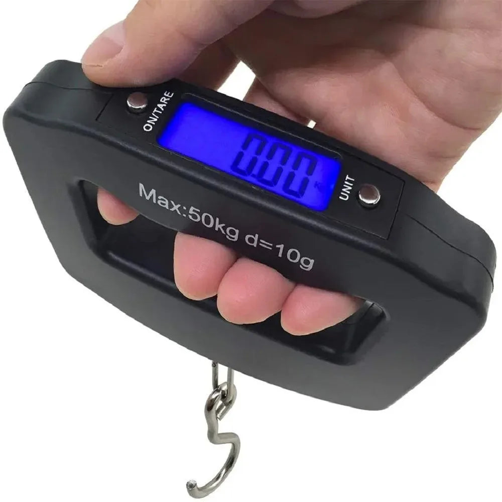 A hand holds a black portable digital luggage scale with a blue backlit display showing 0.00 and a metal hook.