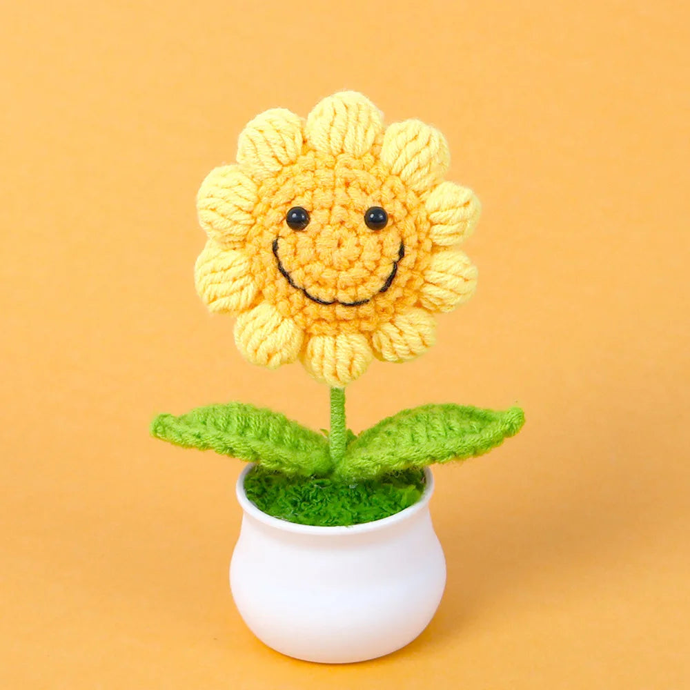 Handcrafted crochet sunflower with a green stem growing in a white pot
