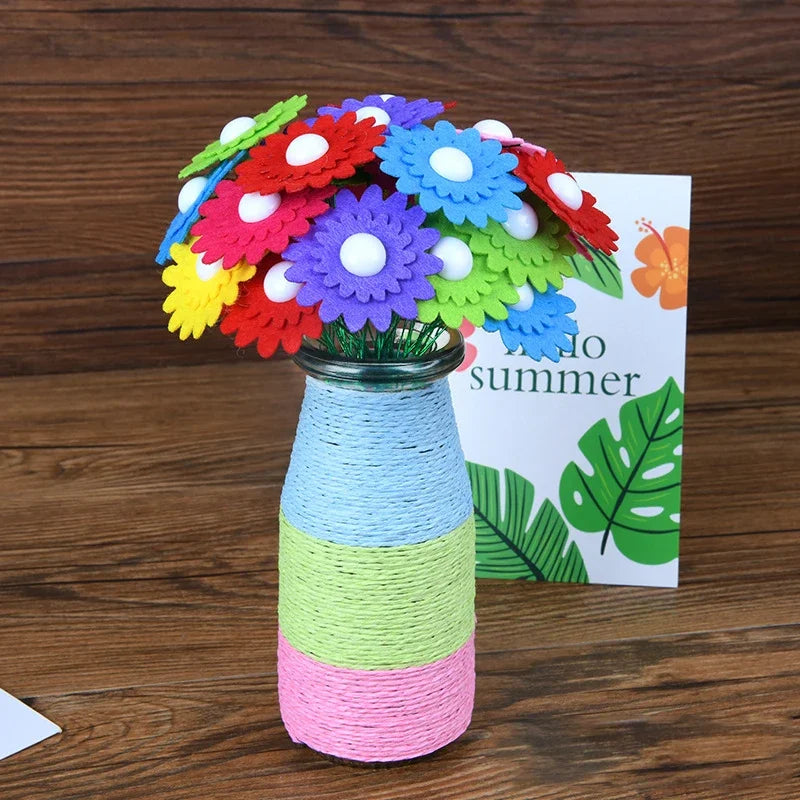 A colorful craft kit featuring felt flowers and buttons arranged in a bouquet, displayed next to a sign reading 'Into Summer'