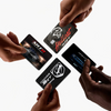 Hands are holding a black credit card skin cover sticker with the Dodge Hellcat SRT logo.