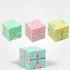 A set of colorful Infinity Magic Cube fidget toys in mint green, pink, and yellow.