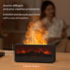 A black ultrasonic aroma diffuser emitting a warm orange flame and light in a wooden setting.
