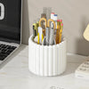 A white cylindrical organizer holds various makeup brushes and tools.