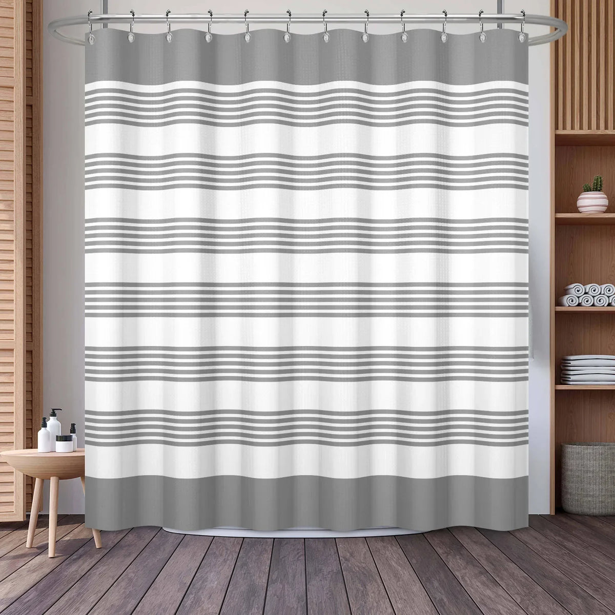 A shower curtain featuring horizontal geometric stripes in shades of gray and white.