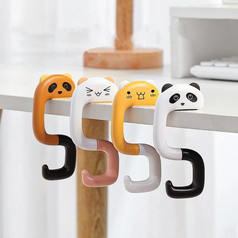 A set of four cute panda-themed silicone hooks in orange, white, yellow, and black hanging from a wooden surface.