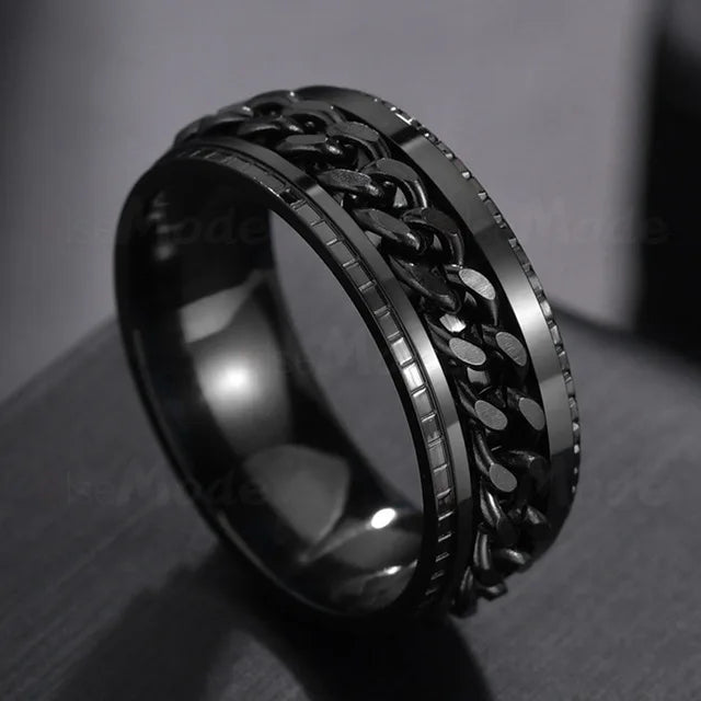 A close-up, black stainless steel spinner ring with a textured link design.