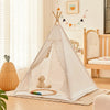 A white foldable play tent with curtains is set up indoors, featuring a stuffed animal inside.