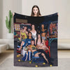 A large print featuring a woman holding a black fabric with colorful imagery and other women in various outfits.