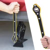 A hand holds a black and yellow ratchet wrench used for tire changes.