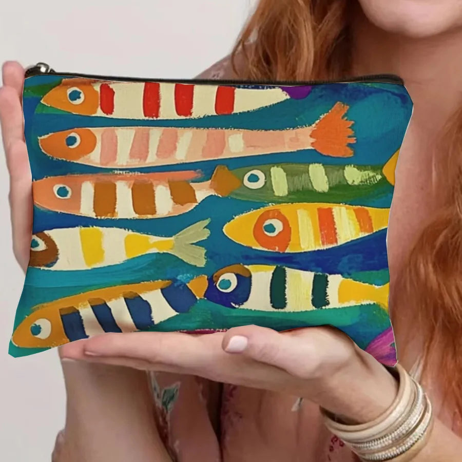 A canvas cosmetic bag featuring a vintage sardine print in various shades of orange, yellow, and green.