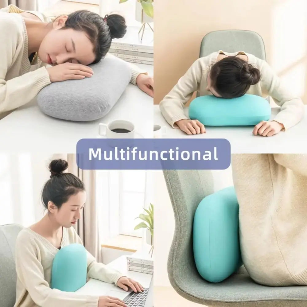 A woman rests her head on a light blue memory foam travel neck pillow while working at a desk.